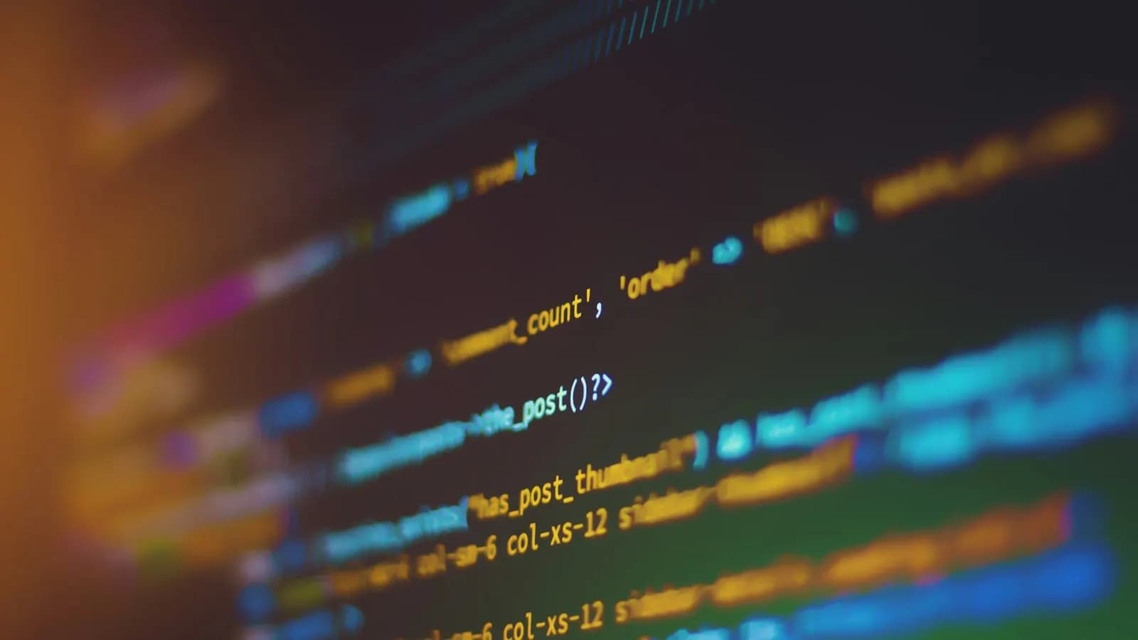 Close-up of syntax-highlighted source code on a dark screen, with most lines blurred out of focus