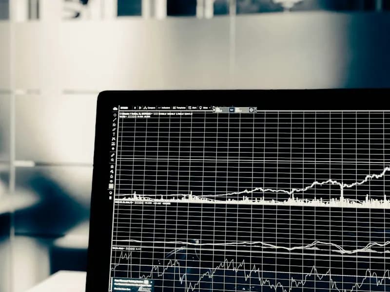 Monochrome photo of a laptop screen displaying time-series line charts on a grid