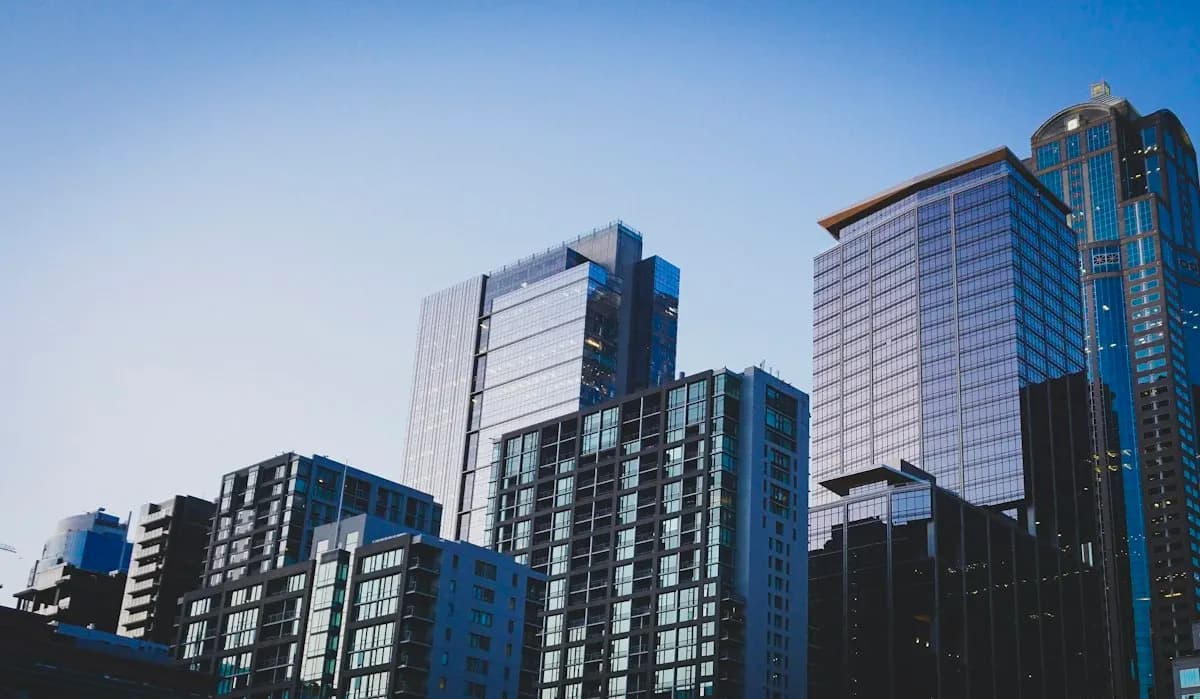 Glass high-rise towers and apartment blocks against a clear blue sky in a downtown skyline